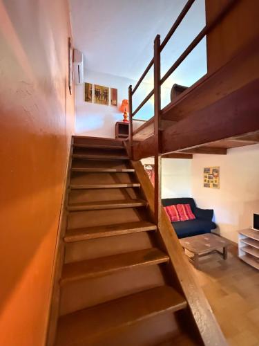 - un escalier en bois dans une chambre avec un canapé dans l'établissement gite au paradis, parc animalier, à Olmeta-di-Tuda