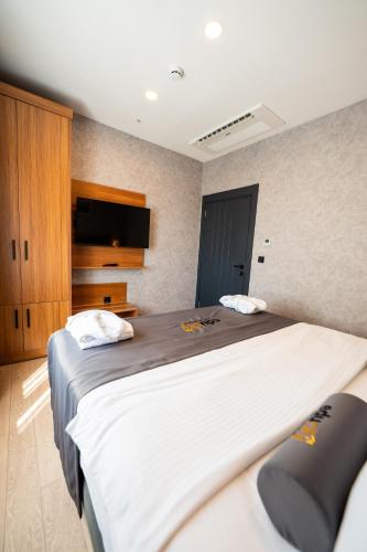 a bedroom with a large bed and a tv at Educity Suite and Hotels Atasehir in Istanbul