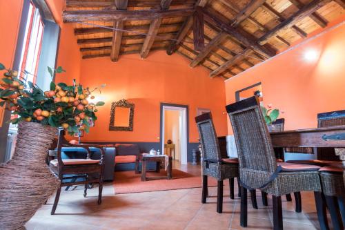 a living room with orange walls and a table and chairs at Agriturismo Borgo Spagnoli in Magione