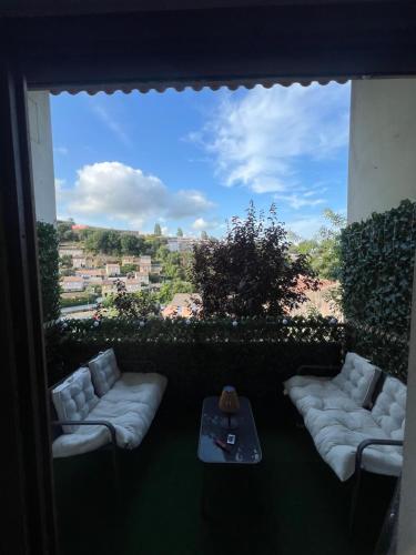 un balcon avec une fenêtre avec des chaises blanches et une table dans l'établissement Charmant duplex, à Villeneuve-Loubet
