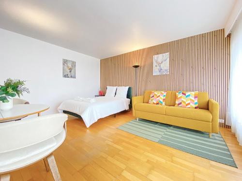 - un salon avec un canapé jaune et un lit dans l'établissement Cosy flat with the view of Eiffel Tower, à Paris