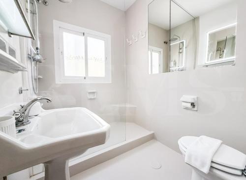 a white bathroom with a sink and a mirror at Marbella House with pool and rooftop terrace REMS in Marbella