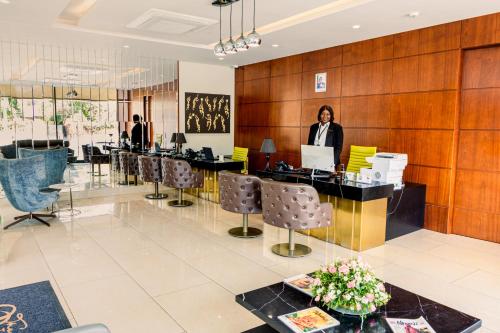 a woman is standing at a desk in a lobby at The Quorum in Lusaka