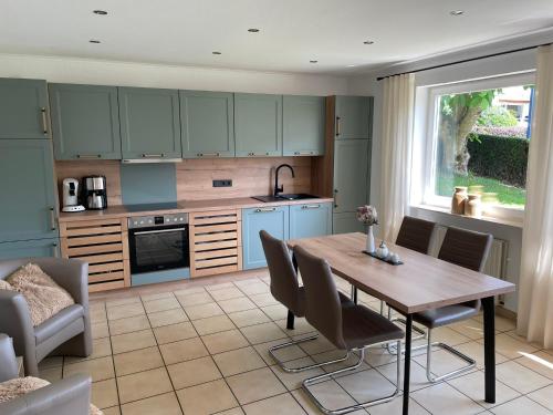 a kitchen and dining room with a wooden table and chairs at Ferienwohnungen Lohmann in Bullay