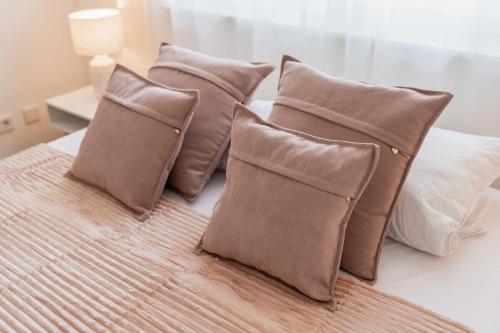 eine Gruppe von Kissen auf einem Bett in der Unterkunft Bay 47° Boutique Apartments am Chiemsee in Übersee