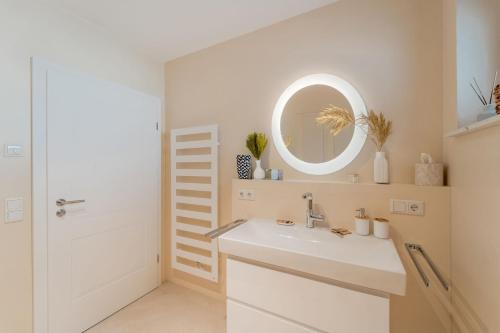 ein Badezimmer mit Waschbecken und Spiegel in der Unterkunft Bay 47° Boutique Apartments am Chiemsee in Übersee