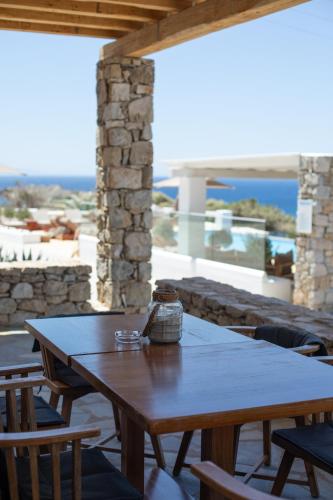 a wooden table on a patio with a view of the ocean at Seethrough Mykonos Suites in Platis Yialos Mykonos