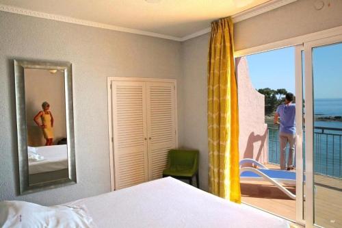 リャンサにあるHotel Grifeuのベッドがあり海が見える寝室