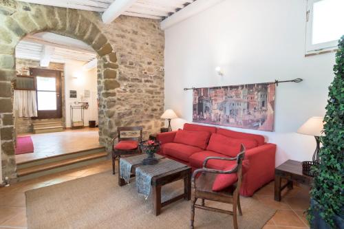 a living room with a red couch and a brick wall at Agriturismo Borgo Spagnoli in Magione