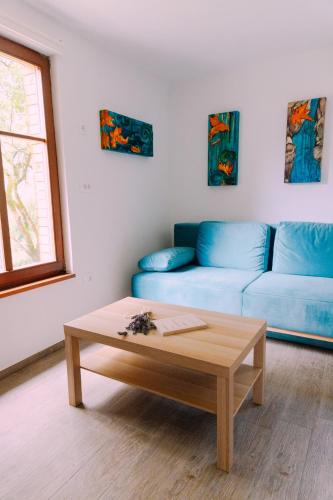 a living room with a blue couch and a coffee table at Apartma BoMa in Bovec