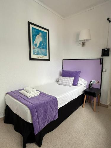 a bed with purple pillows and a purple blanket at Hotel Teide in El Arenal