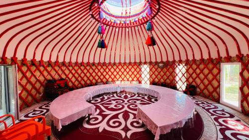 a room with a table and chairs in a yurt at Asylai Guesthouse in Naryn
