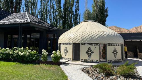 a gazebo in a yard next to a house at Asylai Guesthouse in Naryn