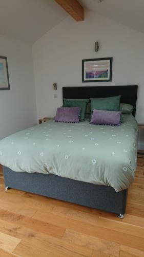a bed in a room with purple pillows on it at Sea Breezes in Oban