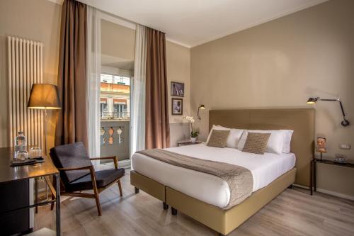 a hotel room with a bed, chair, and table at Nazionale 51 Group in Rome