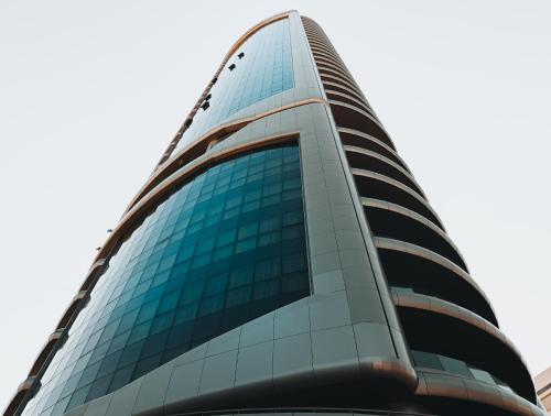 a tall glass office building with blue windows at The 1 -Nicosia Luxe Stay- Gym Pool 24h Concierge in Nicosia