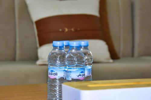 three bottles of water sitting on top of a table at White Majorelle Founty in Agadir