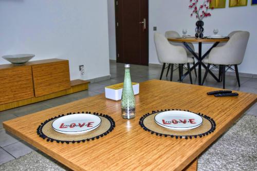 a wooden table with two plates with the words love at White Majorelle Founty in Agadir