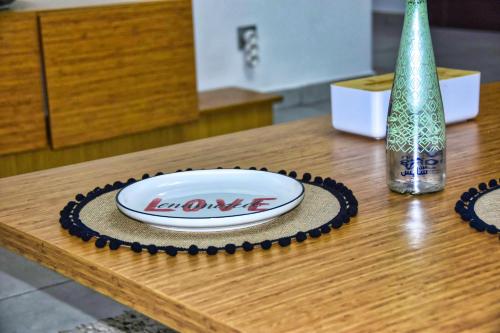 a wooden table with a plate and a bottle on it at White Majorelle Founty in Agadir