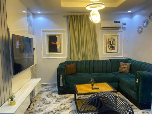 a living room with a green couch and a table at Live By The Water 2-Bed-Apt With Starlink SuperFast Speed Wi-Fi And Secured in Amuwo