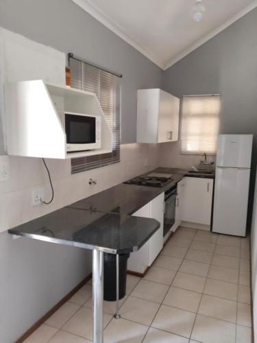 a kitchen with white cabinets and a black counter top at 77 Pendleberry Grove in Warmbaths