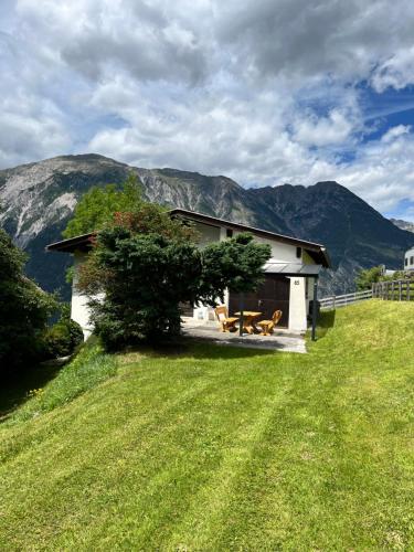 ツァムスにあるStille Auszeitの山を背景にした丘の上の住宅