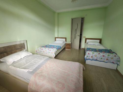 a bedroom with two beds and a door to another room at 53 jincharadze street Makhinjauri, Batumi in Batumi
