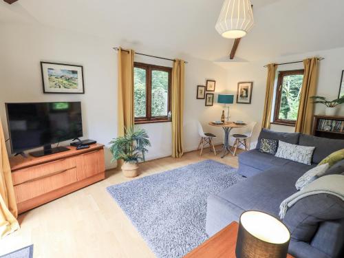 a living room with a couch and a flat screen tv at Doe Foot Cottage in Ingleton