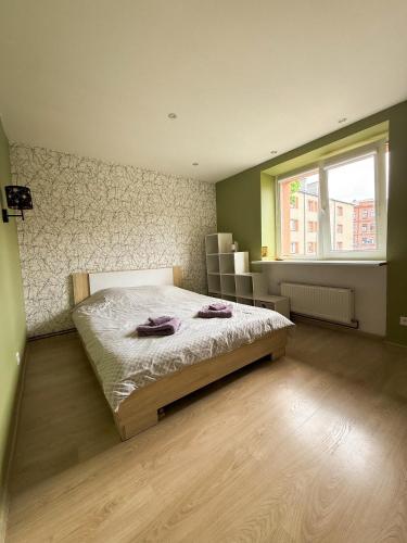 a bedroom with a bed with two towels on it at Piejūras laivinieks in Liepāja