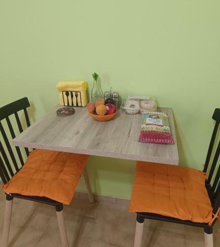 a wooden table with a bowl of fruit on it at The Green House in Adelianos Kampos