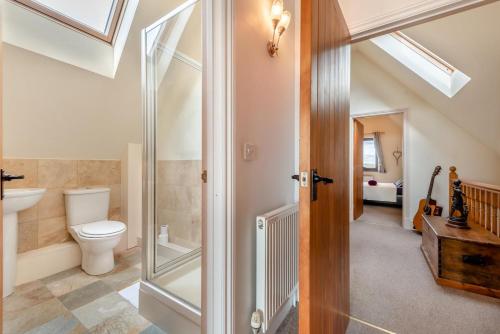 e bagno con servizi igienici e cabina doccia. di Driftwood House a Parkmill