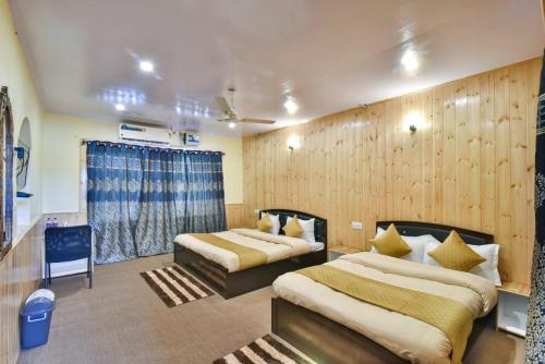 a hotel room with two beds and a window at Hotel Iceland in Srinagar