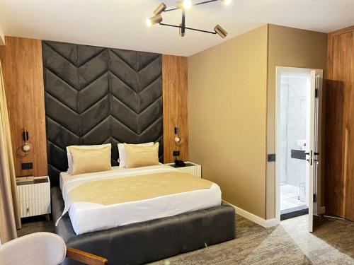 a bedroom with a large bed with a large headboard at White Breeze Hotel in Baku