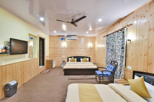 a hotel room with two beds and a flat screen tv at Hotel Iceland in Srinagar