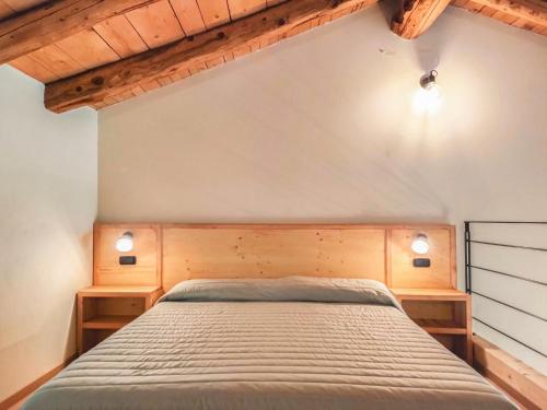 a bedroom with a bed with two wooden shelves at ai Parlenti 25 - openspace in Tirano