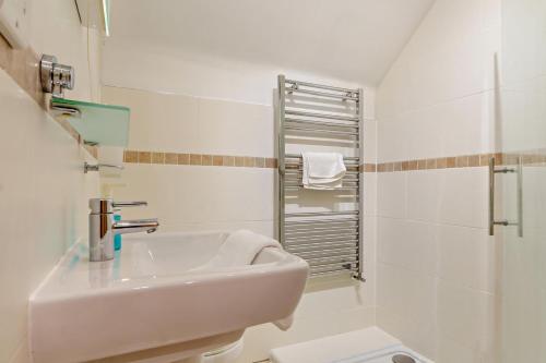 a white bathroom with a sink and a shower at Northwood Farm - The Granary in Ellastone