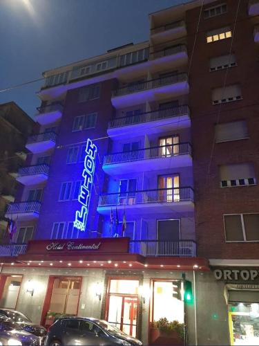 a building with a blue lit up sign on it at Hotel Continental in Turin