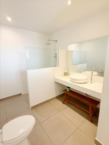 a white bathroom with a toilet and a sink at Aruba Palms Escape Suites in Palm-Eagle Beach
