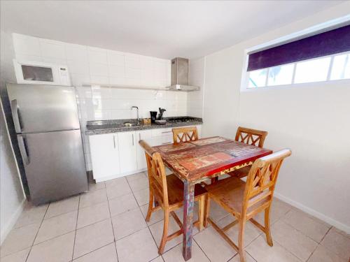 a kitchen with a table and chairs and a refrigerator at Aruba Palms Escape Suites in Palm-Eagle Beach
