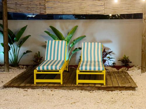 two chairs sitting next to each other on a wooden deck at Aruba Palms Escape Suites in Palm-Eagle Beach