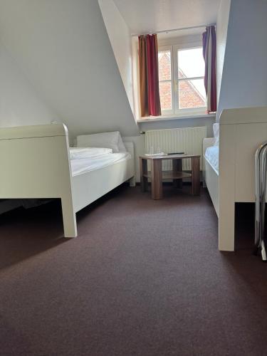 a small room with two beds and a window at Greetsieler Börse in Greetsiel