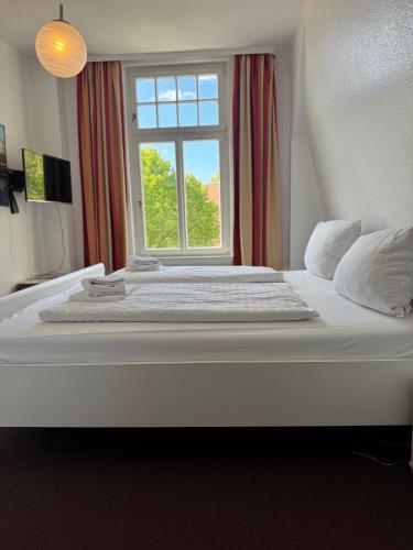 a large white bed in a room with a window at Greetsieler Börse in Greetsiel