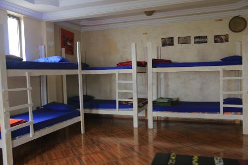 a room with three bunk beds with blue sheets at Mad Vervet Backpackers Hostel in Addis Ababa