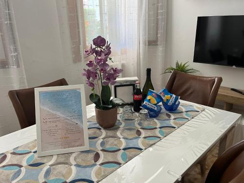 a table with a vase with purple flowers on it at A Casa dei Nonni in Cavallino-Treporti