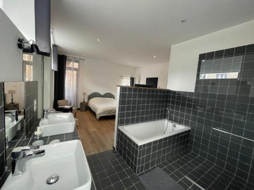 a bathroom with two sinks and a bath tub at La Grange De Salomé in Salomé