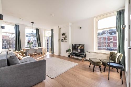 a living room with a couch and a tv at Panoramic canalview apartment in Amsterdam