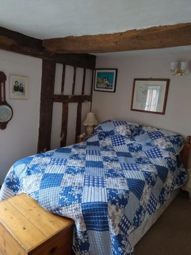 a bedroom with a blue and white quilt on a bed at The Old Sweet Shop in Harwich