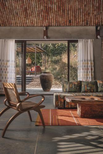 a living room with a chair and a couch at Tipai Wildlife Luxuries in Pahāpal