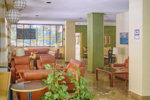 a lobby with leather furniture and stained glass windows at Hotel Paraíso in Lanjarón