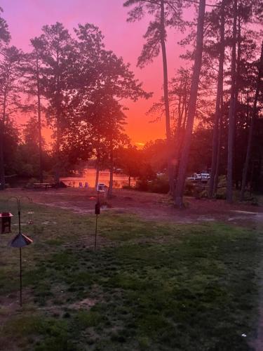 a sunset in a park with a field with trees at Serenity in White Stone